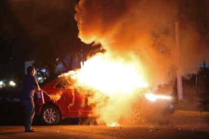 Police officers put out a burning car in Zapopan, Jalisco, on August 10.