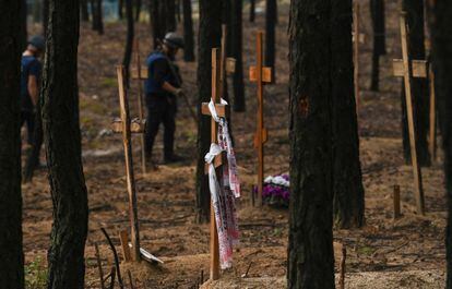 Ukrainian servicemen searching for landmines at a burial site in a forest on the outskirts of Izium on Friday. 