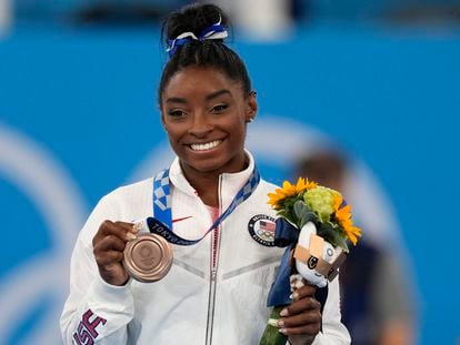 U.S. gymnast Simone Biles poses with her bronze medal for the artistic gymnastics women's balance beam apparatus at the 2020 Summer Olympics, Tuesday, Aug. 3, 2021, in Tokyo, Japan.