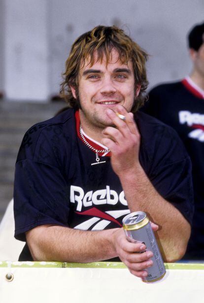Robbie Williams, at the height of his incorrigible rock star era, photographed during a charity match in 1996.