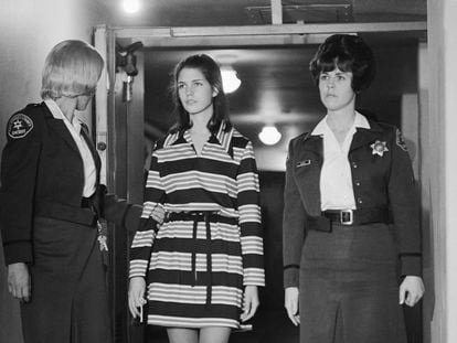 Leslie Van Houten, 19, a member of Charles Manson's "family" who is charged with the murders of Leno and Rosemary LaBianca, is escorted by two deputy sheriffs as she leaves the courtroom in Los Angeles, Dec. 19, 1969, after a brief hearing.