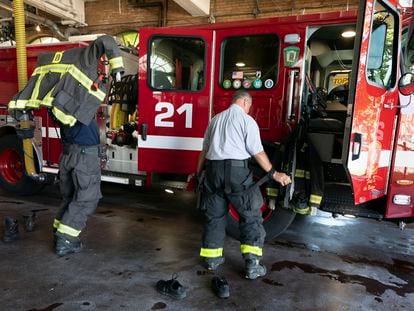 Firefighter Rod MacKinnon, left, and Lt. Chris Stevens don their turnout gear as they respond to a call at the Engine 21 fire station, Thursday, Aug. 24, 2023, in the Dorchester neighborhood of Boston.