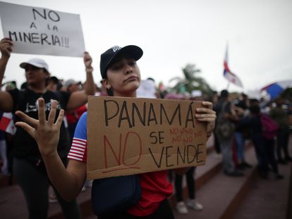 A protester holds a sign with the phrase "Panama is not for sale", during one of the protests against the mining contract, in Panama City, October 24.