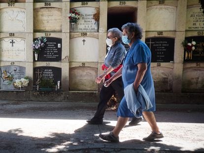 Two seniors wearing masks make a visit to a cemetery in Pamplona, northern Spain.