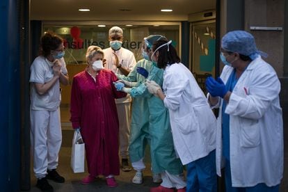 Health workers in Barcelona applaud a coronavirus patient after she is discharged from hospital.