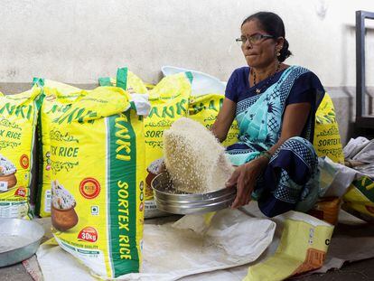 A woman cleans rice grains at a wholesale market in Navi Mumbai, India, August 2023.