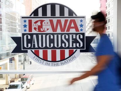 A pedestrian walks past a sign for the Iowa Caucuses on a downtown skywalk, in Des Moines, Iowa, on Feb. 4, 2020.
