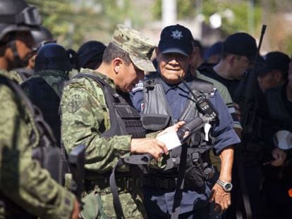 Members of the Mexican army disarm municipal police officers in Apatzingán.