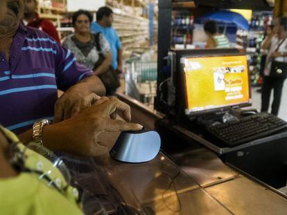 Supermarket customers using the new biometrics system in Maracaibo.