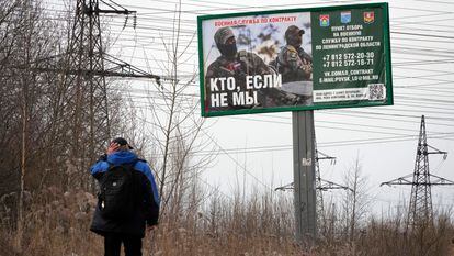 A man walks past an army recruitment advert on a billboard reading 'Who if not us' outside St. Petersburg, Russia, on  April 11, 2023. 