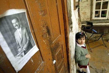 Lileana Khalil, 6, looks at a picture of Iraqi President Saddam Hussein in her bedroom in the Little Abu Newas neighborhood in Baghdad, Iraq, on January 30, 2003