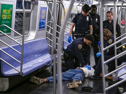 Police officers trying to revive the victim on Monday in a subway car in New York.