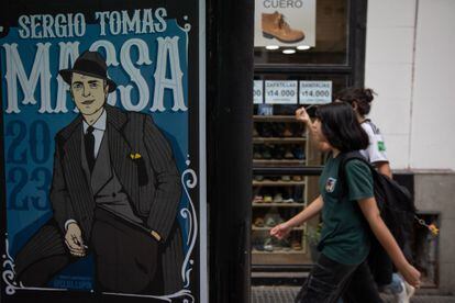 Pedestrians walk in front of one of Sergio Massa's posters in Buenos Aires.