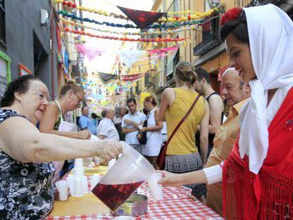 A woman serves sangría during Madrid's San Cayetano festivities.