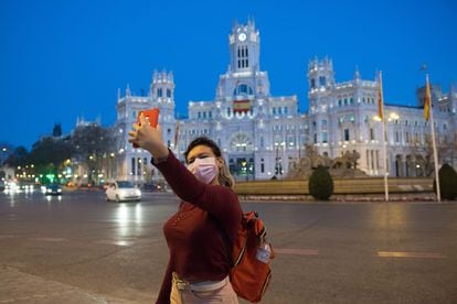 A woman takes a selfie at on the streets of a deserted Madrid.
