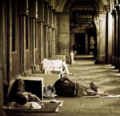 Homeless people sleep underneath the arches of Madrid's Plaza Mayor.