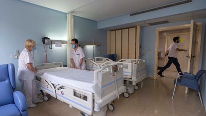 Two healthcare workers prepare a room in the Hospital Universitario Morales Meseguer in Murcia, after the last coronavirus patient there was discharged.