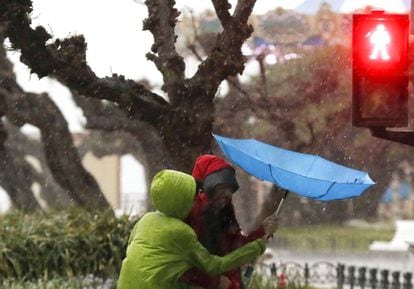 Tourists shield themselves from the rain in San Sebastián.