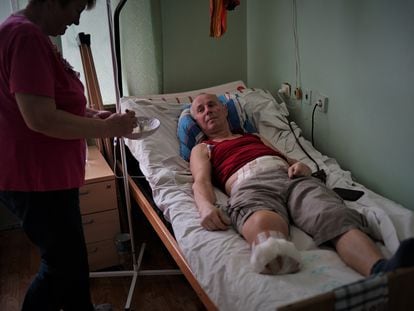Zina feeds her husband Vasil, who lost his lower leg after being shot in cold blood by a Russian officer.