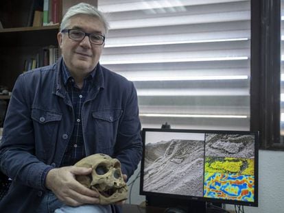 Fernando Muñiz, one of the researchers who discovered the Neanderthal’s footprint, holds up a Neanderthal skull while displaying the evidence found in Gibraltar.