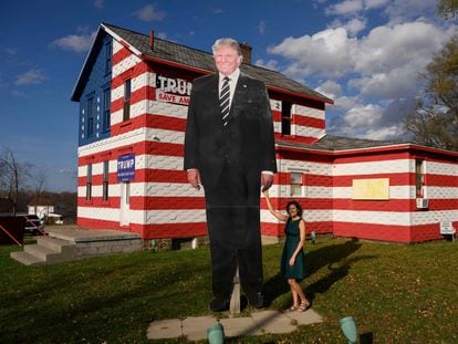 Pennsylvania State Rep. Leslie Rossi poses with a giant cutout of former US President Donald Trump in front of the "Trump House," which she created in 2016, in Youngstown, Pennsylvania on November 6, 2022.