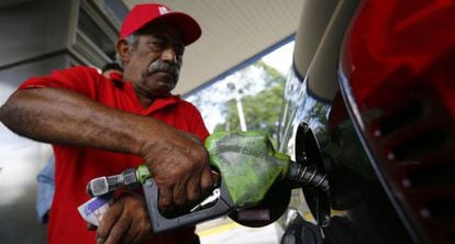 A man fills up his car with gas in Caracas.