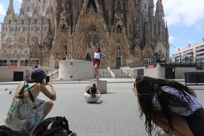 Tourists in Barcelona, in front of the Sagrada Família cathedral.