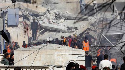 People and rescuers gather in front of a building destroyed in a reported Israeli strike in Damascus on January 20, 2024.