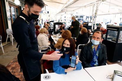 A patron shows her waiter her Covid passport on December 20 in Málaga, Andalusia.