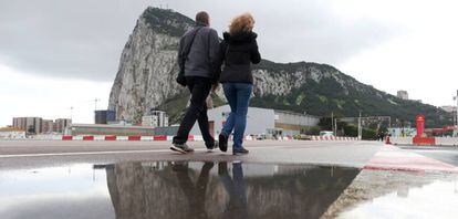 Two people cross the airport of Gibraltar.