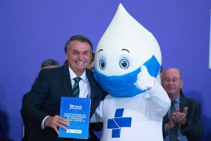 Bolsonaro poses next to “Droplet Joe” – a mascot created to promote vaccination campaigns in Brazil – during the launch of the national COVID-19 vaccination plan, held at the Planalto Palace on December 16, 2020, in Brasilia.