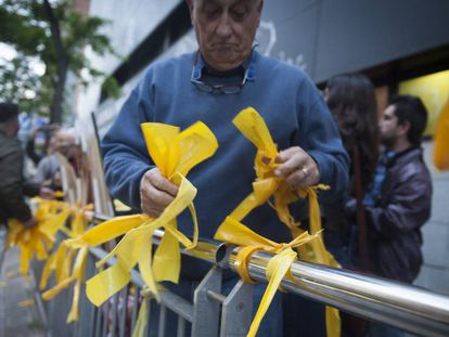 A man removes yellow ribbons from a public space in Catalonia.