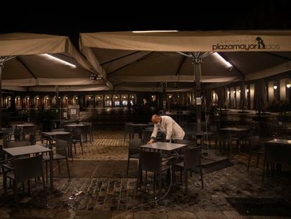 A waiter closes the terrace of a bar in Plaza Mayor, Madrid on Friday.