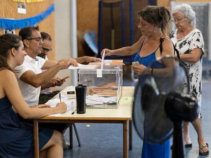 A woman votes in a Barcelona polling station equipped with multiple fans, this Sunday.