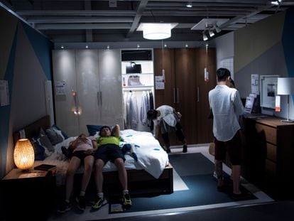 Two youths lie on the bed in one of the display apartments at an IKEA in Shanghai.