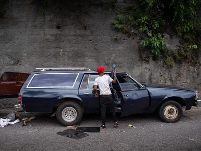 A man cleans a station wagon converted into a hearse in Caracas' Petare neighborhood; June 3, 2023.