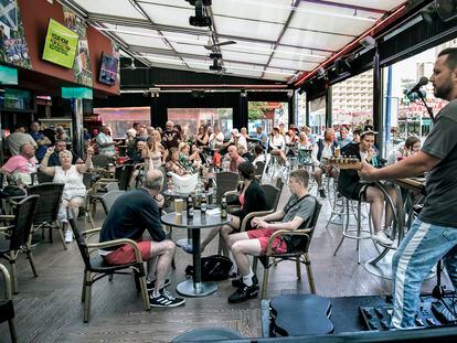 UK tourists listen to live music at a bar in Benidorm.