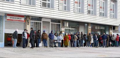 People stand in line outside an employment office.
