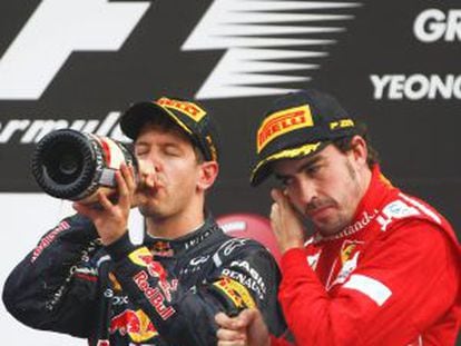 Sebastian Vettel (l) drinks champagne on the podium after winning the South Korean Grand Prix next to third-placed Fernando Alonso.