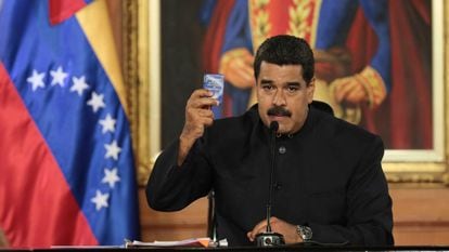 Maduro holds a copy of the Venezuelan Constitution during a speech.