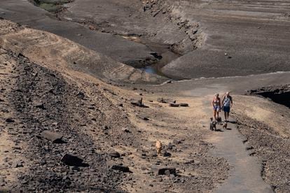 A couple crosses an old bridge exposed by low water levels at Baitings Reservoir in Yorkshire on August 12.