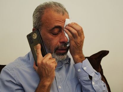 Mohamed Farra, 45, takes a call of condolence for the death of his sister, brother-in-law, and three nieces in Gaza.