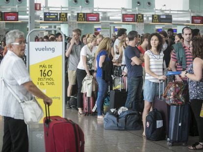 Passengers lining up at Vueling counters at Barcelona airport.