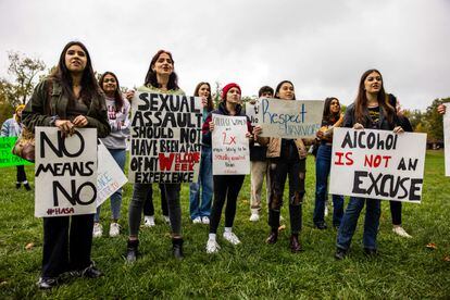 Women hold up signs with myths about rape during a 2021 protest for victims of sexual assault in Bloomington, Indiana.