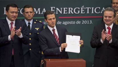 President Enrique Pe&ntilde;a Nieto (c), next to Energy Secretary Pedro Joaqu&iacute;n Coldwell (r) and Mexican Interior Minister Miguel Osorio Chong (l), shows the reform bill on Monday.