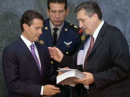 González (right) delivers his report to President Peña Nieto.