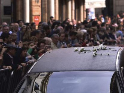 Hundreds of people line the streets of Seville as the funeral car of the Duchess of Alba passes. 