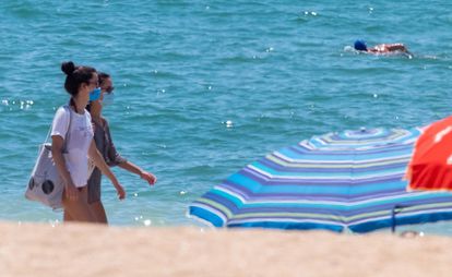 Beachgoers wearing face masks on the beach in La Antilla, in Andalusia's Huelva province.