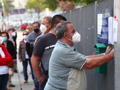 People wait in line outside a cultural centre to take a coronavirus antigen test in the Madrid neighborhood of Vallecas.