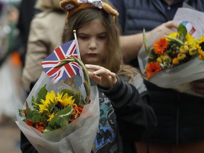 A young girl holds flowers outside Buckingham Palace in London, Britain, 10 September 2022.